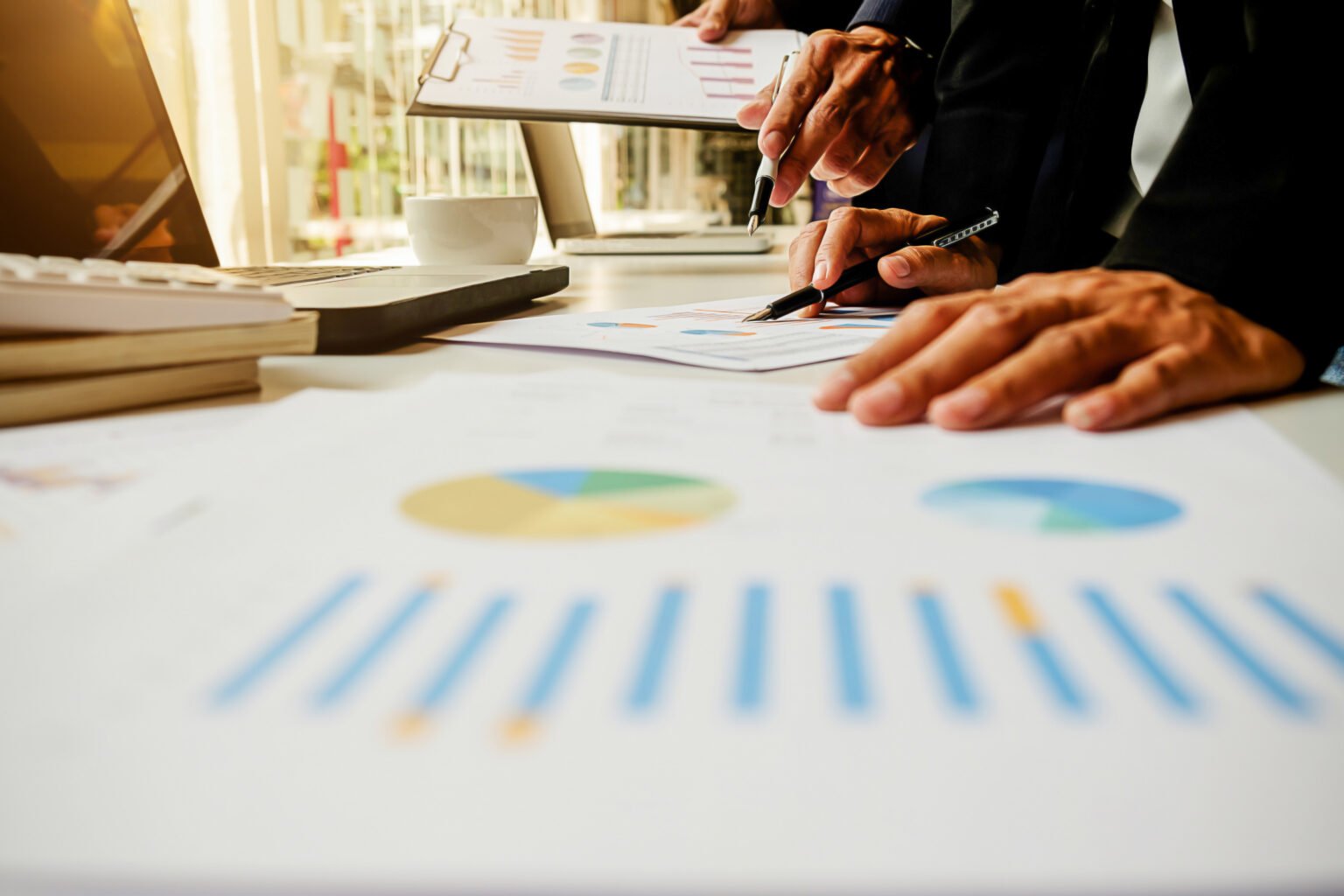 Business concept. Business people discussing the charts and graphs showing the results of their successful teamwork. Selective focus.